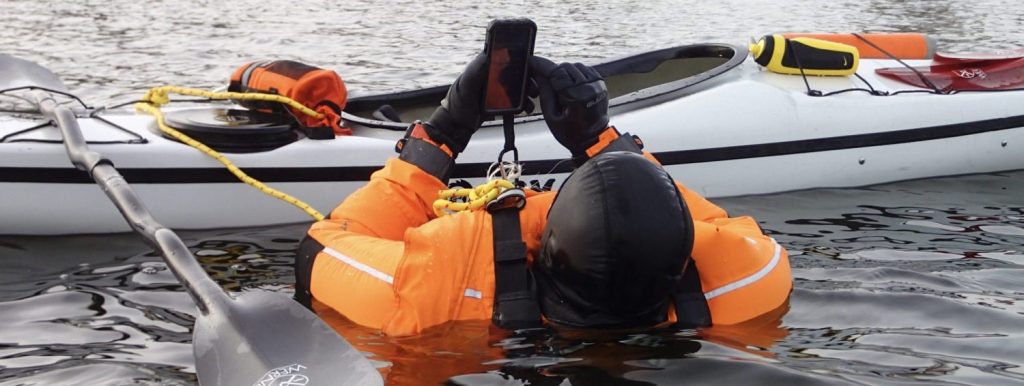 kajakroer på vandet med telefon førstehjælp